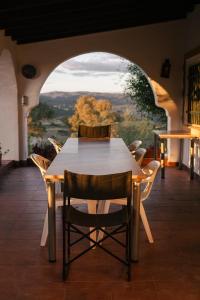 Una mesa y sillas en una habitación con ventana. en El Brinco, en Aznalcóllar