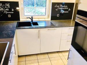 a kitchen with white cabinets and a sink and a window at Luxury Retreat near Beach - By Traum Ferienwohnungen in Marielyst +14 photos