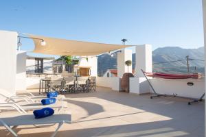 - un balcon avec des chaises, une table et un bateau dans l'établissement Athina House Spa & Hammam, à Arkhondikí
