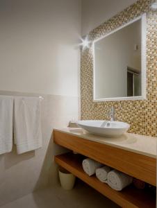 
a bathroom with a sink, mirror, and towel rack at Hotel Moderno in Trapani
