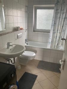 a bathroom with a toilet and a sink and a tub at Grace in Wathlingen