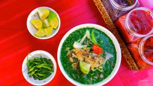 ein roter Tisch mit Schüsseln voller Essen und Gemüse in der Unterkunft Nile Hotel Phu Yen in Tuy Hoa