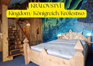 a bedroom with a bed with a painting of a mountain at Hotel Kocourkov in Hlinsko