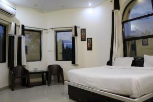 a bedroom with a bed and a table and chairs at Quila Camps and Resort, Burja in Alwar