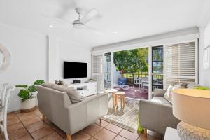 ヌーサヴィルにあるVilla Aqua 6 - Riverfront Noosavilleのソファとテレビのあるリビングルーム