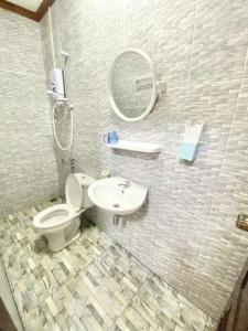 a bathroom with a toilet and a sink and a mirror at Luangprabang Suankeo boutique Villa in Luang Prabang