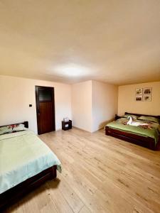 a bedroom with two beds and a wooden floor at CASA Maria in Orlat