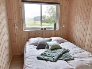 a bed in a wooden room with a window at Luxury Retreat by the Sea - By Traum Ferienwohnungen in Høruphav