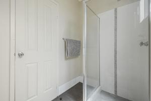a shower with a glass door in a bathroom at Terrific Townhouse 3x2 in CBD in Port Hedland +8 photos
