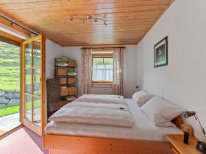 a large bed in a room with a window at Alpenapartment mit Garten in Trauchgau