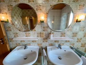 a bathroom with two sinks and two mirrors at Hesselberg-Oase Ferienhof Hüttner in Röckingen