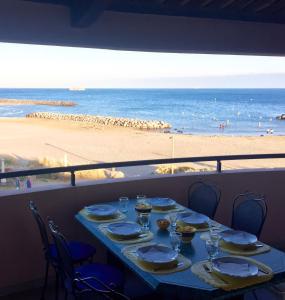 - une table sur un balcon avec vue sur la plage dans l'établissement Savanna Beach, au Cap d'Agde