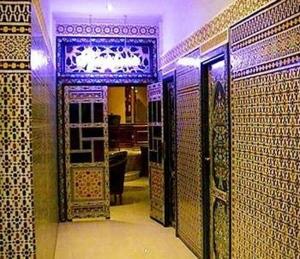 a bathroom with a doorway with a tile wall at Hotel Mounia in Fez