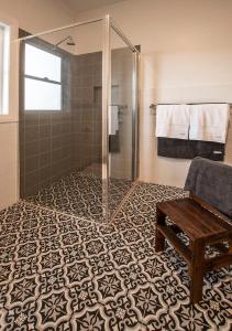 a bathroom with a shower and a bench on a tile floor at Cozy Cottage Blue Mountains in Lowther