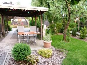 a patio with a table and chairs in a garden at Ferienhaus Christina in Medebach
