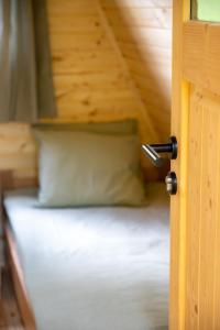 una porta aperta su un letto con un cuscino di GLAMPING BRUNDO - Tents and Cottage with SAUNA & JACUZZI a Kostel
