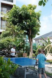 two boys playing ping pong on a ping pong table at Eden Hotel Cát Bà in Cat Ba