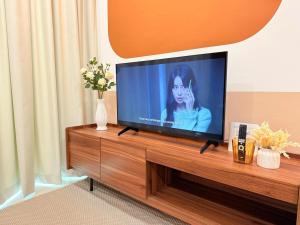 a flat screen tv sitting on top of a wooden entertainment center at Jeff & Ricky Homestay143-Kenny Hiil Residence in Kuching