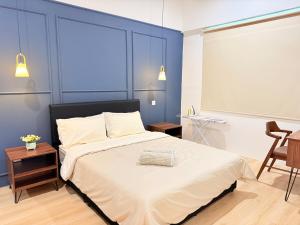 a bedroom with a large bed with a blue wall at Jeff & Ricky Homestay143-Kenny Hiil Residence in Kuching
