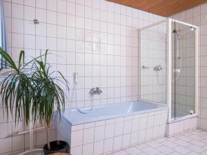 Un baño con bañera y una planta en maceta. en Ferienwohnung, Furtwangen, en Furtwangen 32 fotos más