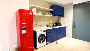 La cocina está equipada con nevera roja y lavadora. en ICC Premium Suites Ipoh by Byon, en Ipoh