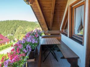 a balcony with a wooden table and flowers at Ferienwohnung, Furtwangen in Furtwangen