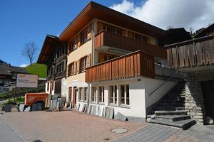 un edificio con balcones de madera en un lateral en Apartment Strassscheuer 3.5 - GriwaRent AG, en Grindelwald