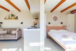 a bedroom with a bed and a couch at Casa Duna Domburg in Domburg