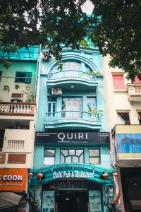 a tall blue building with a sign on it at Quiri Hostel Hanoi in Hanoi