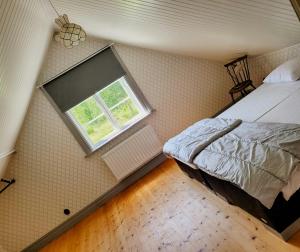 an attic bedroom with a bed and a window at Rural 19Th Century House Near Götlunda in Arboga