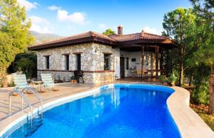 une villa avec piscine devant une maison dans l'établissement The Regency Cottage, à İslâmlar