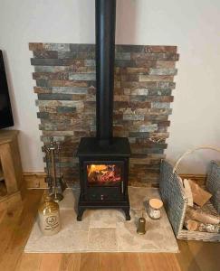einen Kamin mit einem Herd im Wohnzimmer in der Unterkunft The Old Dairy Cottage in Gainford