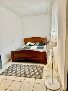 1 dormitorio con 1 cama y ventilador en una habitación en Makepe House, en Douala