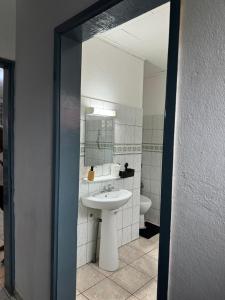 un baño con lavabo e inodoro en Makepe House, en Douala