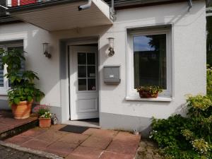 a white house with a door and a window at Ferienwohnung in Löwensen mit eigener Terrasse in Bad Pyrmont