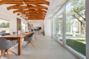 a dining room with a long wooden table and chairs at Villa Olea Pridraga ZadarVillas in Pridraga