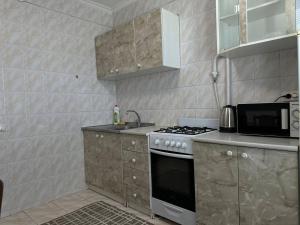 a kitchen with a stove and a microwave at 2-к квартира в Черновцах in Chernivtsi