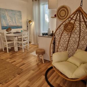 a living room with a swing chair and a table at Blue Cactus village center in Agia Pelagia