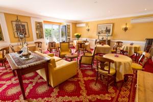 a restaurant with tables and chairs in a room at Hotel Splendid in Cannes