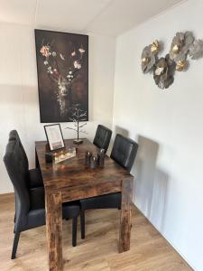 a dining room table with chairs and a wooden table and a picture at Woonboot De Witte loosdrechtse plassen in Loosdrecht
