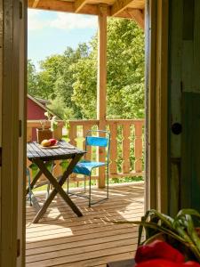 a porch with a table and a blue chair at Charming Apartment In Artists Home From 1899 in Lönsboda