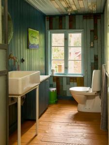 a bathroom with a sink and a toilet and a window at Charming Apartment In Artists Home From 1899 in Lönsboda