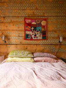 a bed in a room with a wooden wall at Charming Apartment In Artists Home From 1899 in Lönsboda +17 photos