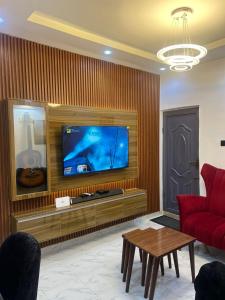 a living room with a red couch and a flat screen tv at Melford Homes in Lagos