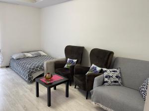 a bedroom with a bed and two chairs and a table at Centrum Apartment Lipowa 12 in Białystok