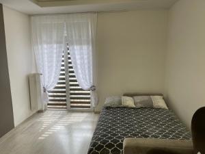 ビャウィストクにあるCentrum Apartment Lipowa 12のベッドと大きな窓のある寝室