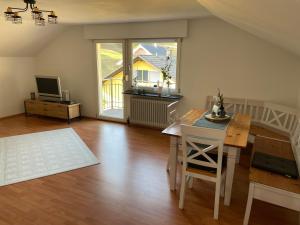 a living room with a dining room table and a television at Black Forest Lodge in Baiersbronn