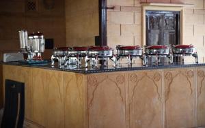 a counter with a bunch of pots and pans at Hotel Bhanwar Haveli in Jaisalmer