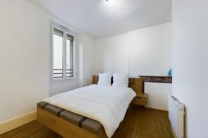 una camera da letto bianca con un letto e una finestra di La Champenoise - Private Garden with Covered Patio a Romilly-sur-Seine
