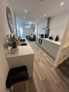 eine Küche und ein Wohnzimmer mit einer Theke und einer Küche und einer Treppe in der Unterkunft Hunters House Flat 6 Sleeps 3 long stays Free Wi-Fi in Swindon